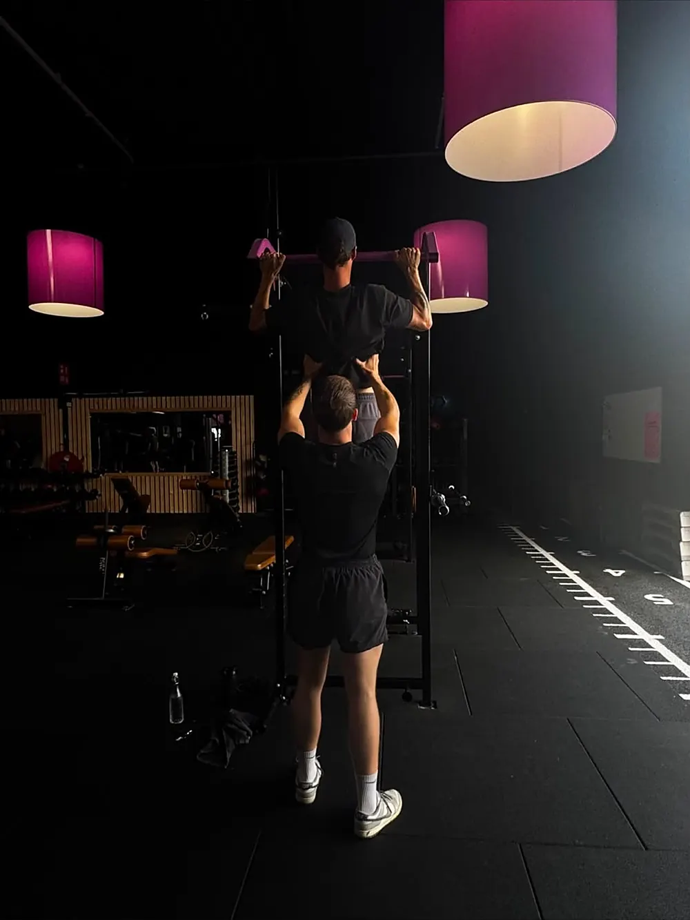 Dion helpt een cliënt door de laatste herhalingen van een pull-up
